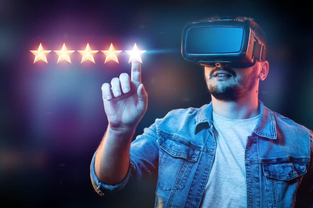 A young man with virtual reality glasses puts 5 stars, assigning a new rating, rating services, a new level, business concept